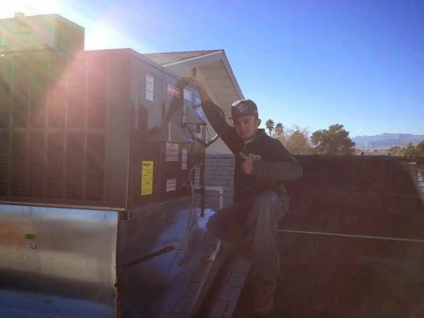HVAC technician performing Air Duct Cleaning on a rooftop unit in Lyndon